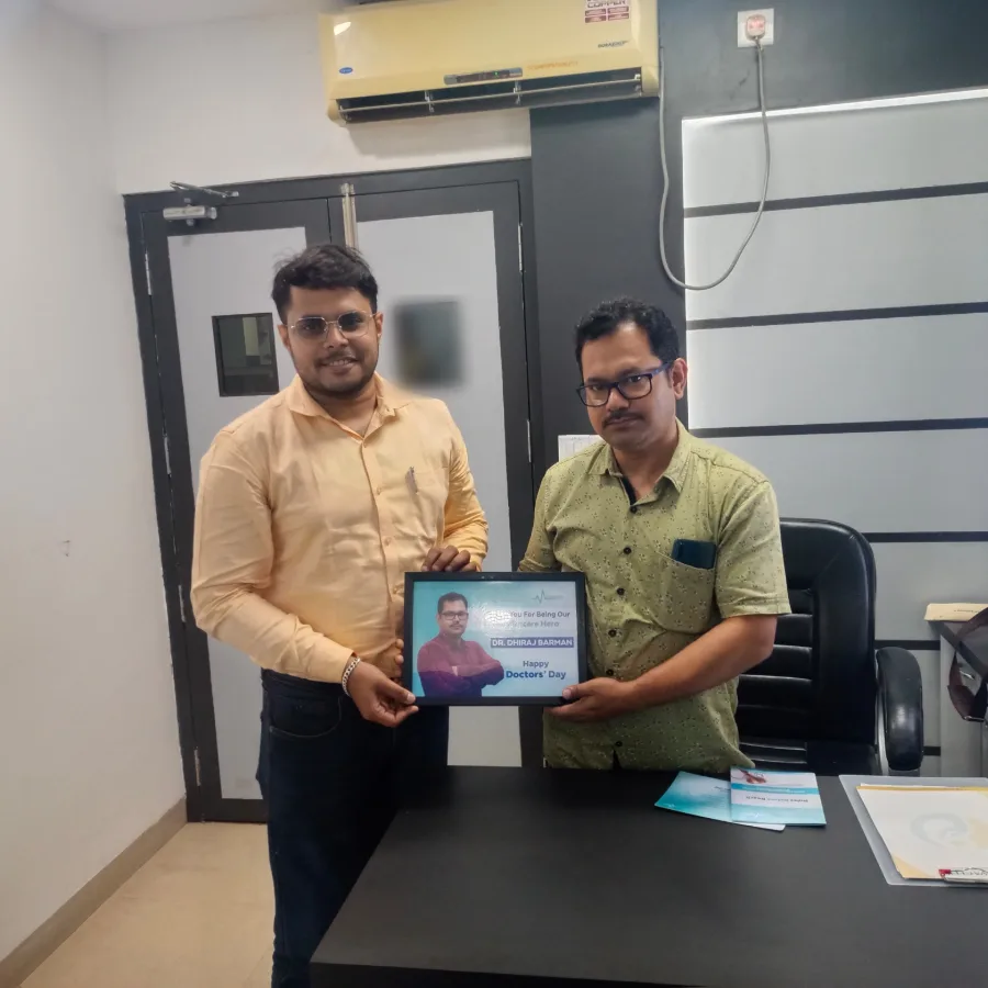 Dr. Dhiraj Barman with a Medmatis team member, printed copies of Rules Before Reach on the desk