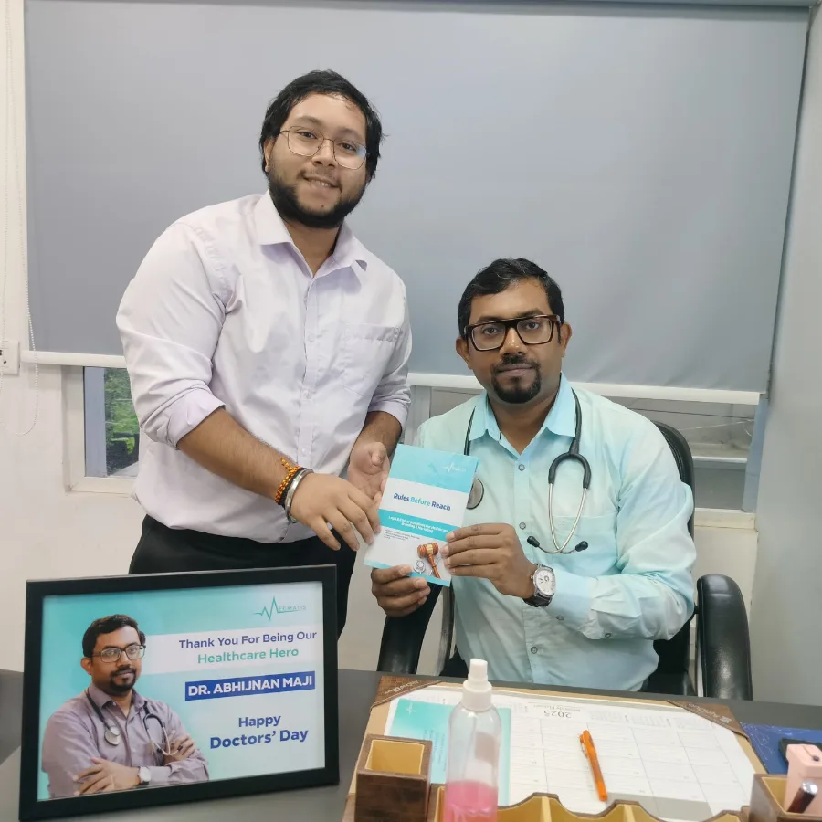 Dr. Abhijnan Maji holding a printed copy of Rules Before Reach, with a Medmatis team member beside him