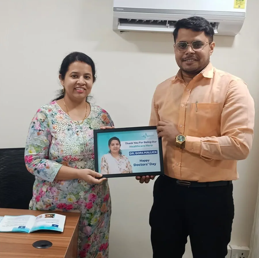 Dr. Gopa Mallick with a Medmatis team member, a copy of Rules Before Reach on the desk