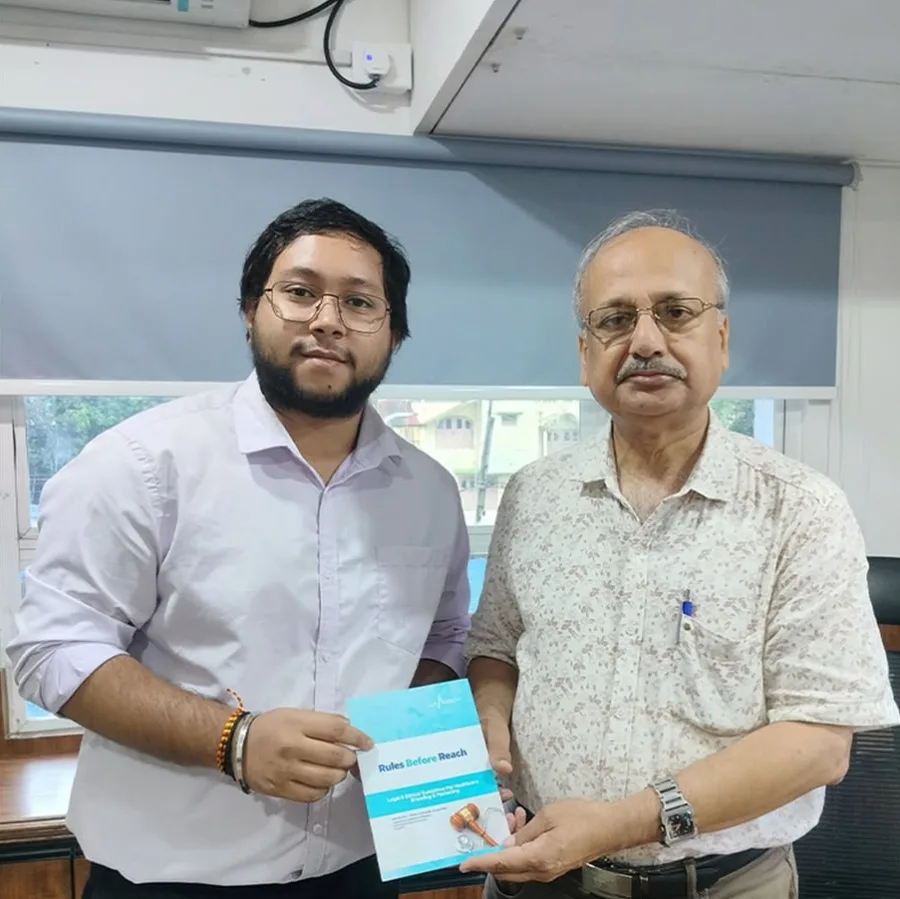 Prof. Dr. Pradip Kumar Mitra holding a printed copy of Rules Before Reach beside a Medmatis team member