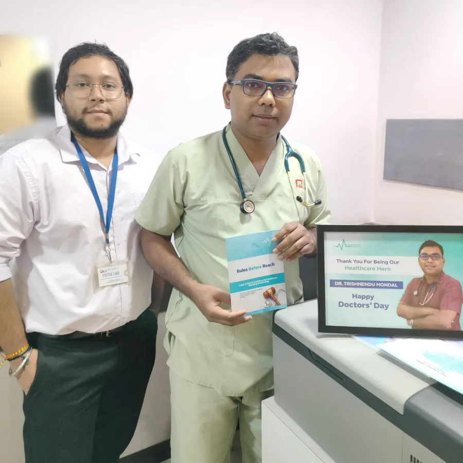 Dr. Trishnendu Mondal holding a printed copy of Rules Before Reach, with a Medmatis team member beside him